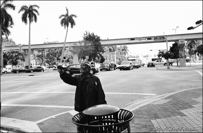 Homeless man holding a dollar on Biscayne Boulevard in Downtown Miami, Florida, USA, 2011. Street Photography of Miami, San Francisco and Key West by Emir Shabashvili, see http://street-foto.com, http://miamistreetphoto.com, http://miamistreetphotography.com or http://miamistreetphotographer.com
