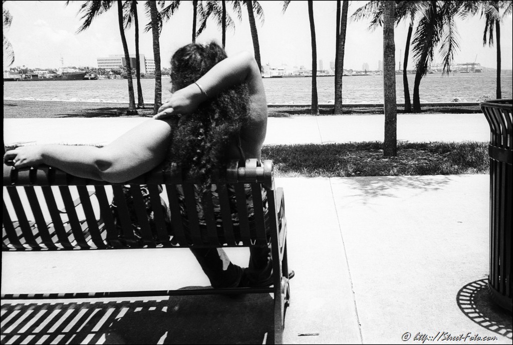 Woman resting on the bench in Bayfront park in Downtown Miami, Florida, USA, 2011. Street Photography of Miami, San Francisco and Key West by Emir Shabashvili, see http://street-foto.com, http://miamistreetphoto.com, http://miamistreetphotography.com or http://miamistreetphotographer.com