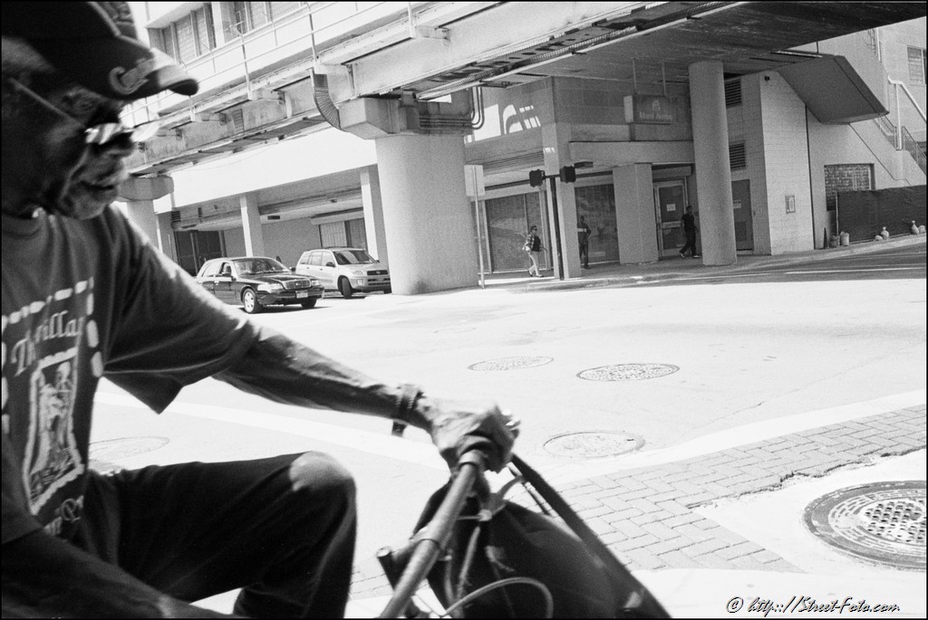 Man riding a bike in downtown Miami, Florida, USA, 2011. Street Photography of Miami, San Francisco and Key West by Emir Shabashvili, see http://street-foto.com, http://miamistreetphoto.com, http://miamistreetphotography.com or http://miamistreetphotographer.com